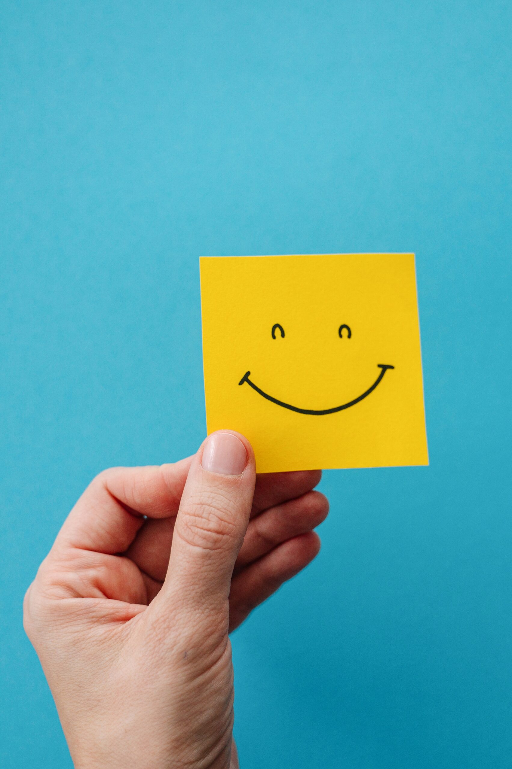 Happy,Face,Icon,On,A,Blue,Background.,A,Hand,Holds